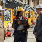 Female foreman using digital tablet in her work during her meeting with engineers in factory