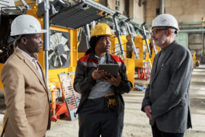 Female foreman using digital tablet in her work during her meeting with engineers in factory