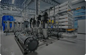 A modern industrial water filtration setup featuring multiple pumps and large pipes, with a series of white filtration membranes in the background, inside a well-lit facility