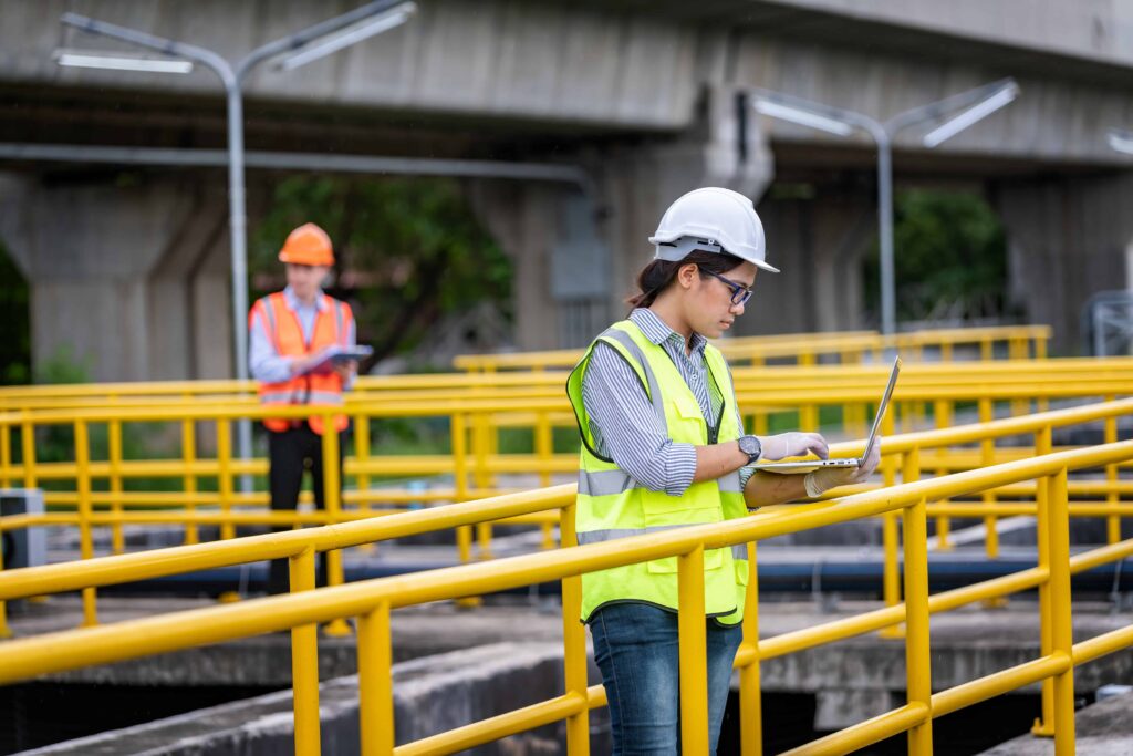 Engineer taking water from wastewater treatment pond