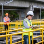 Engineer taking water from wastewater treatment pond