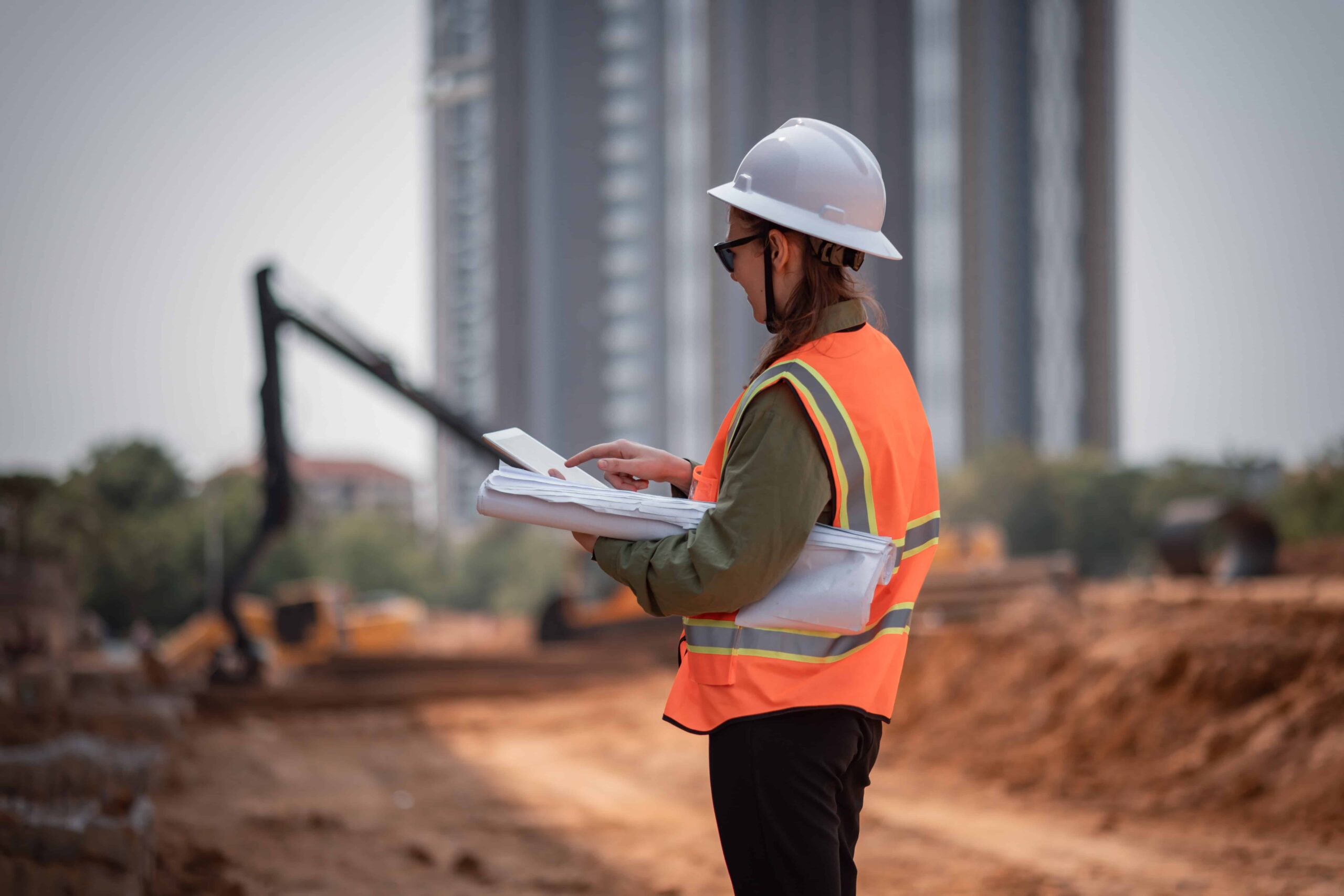 Construction manager looks over construction plans at a job site