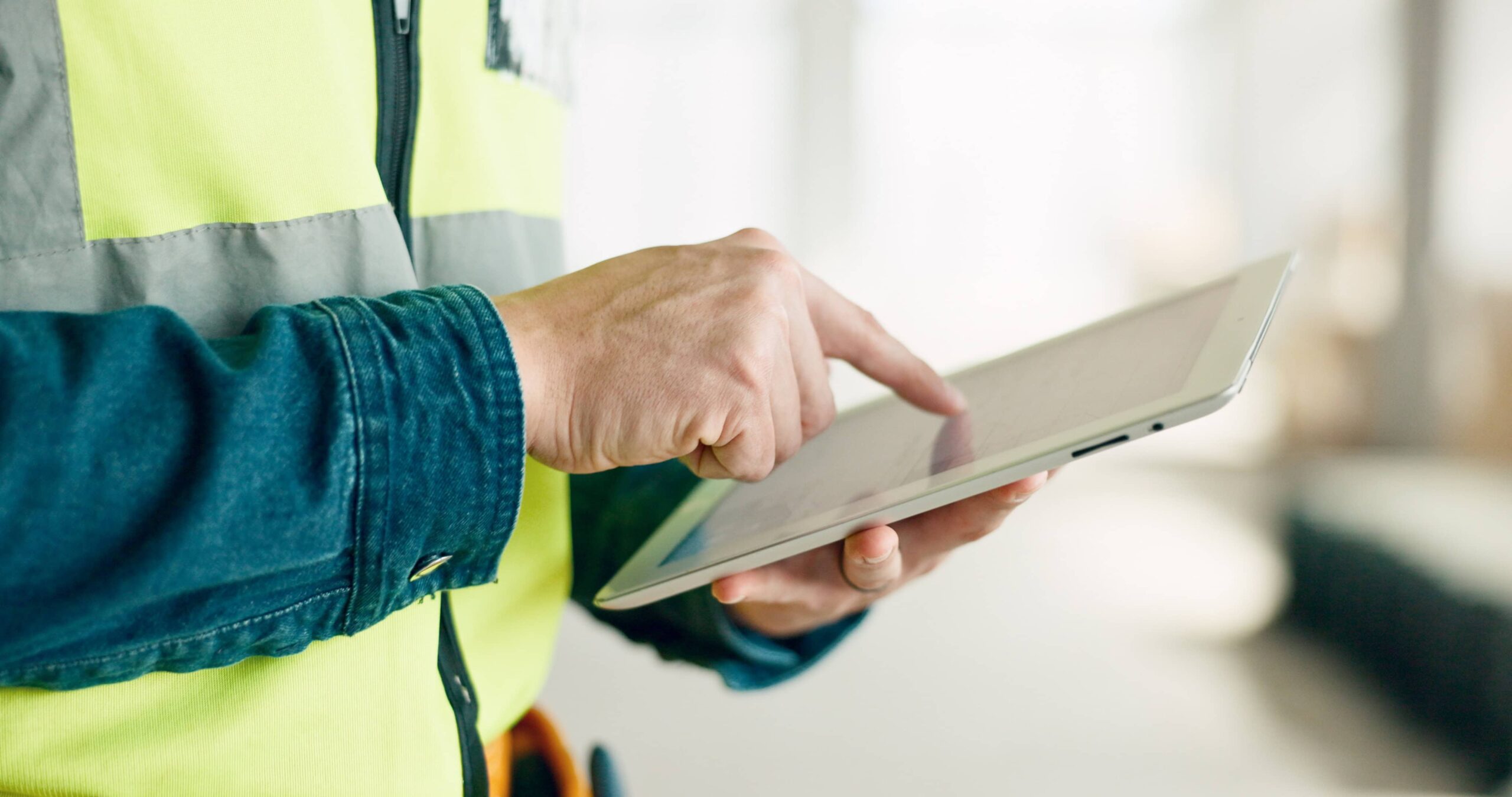 Contractor reviewing pay application on a digital tablet at a construction site