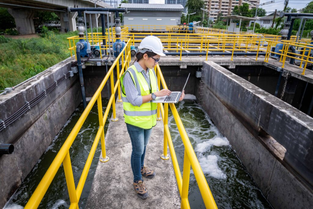 Engineer taking samples from wastewater treatment pond