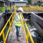 Engineer taking samples from wastewater treatment pond