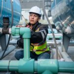 Engineer checking the integrity of industrial equipment wearing proper personal protective equipment