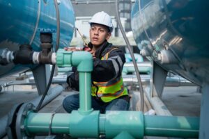 Engineer checking the integrity of industrial equipment wearing proper personal protective equipment