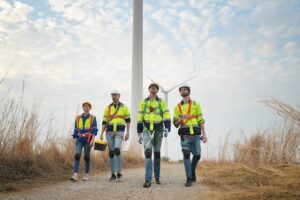 Wide perspective of wind turbine engineers walking down a concrete path