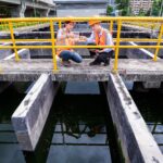 engineers take water samples from wastewater treatment pond