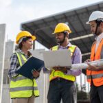 construction workers discussing project on laptop