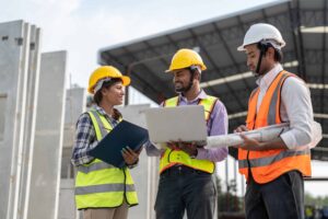 construction workers discussing project on laptop